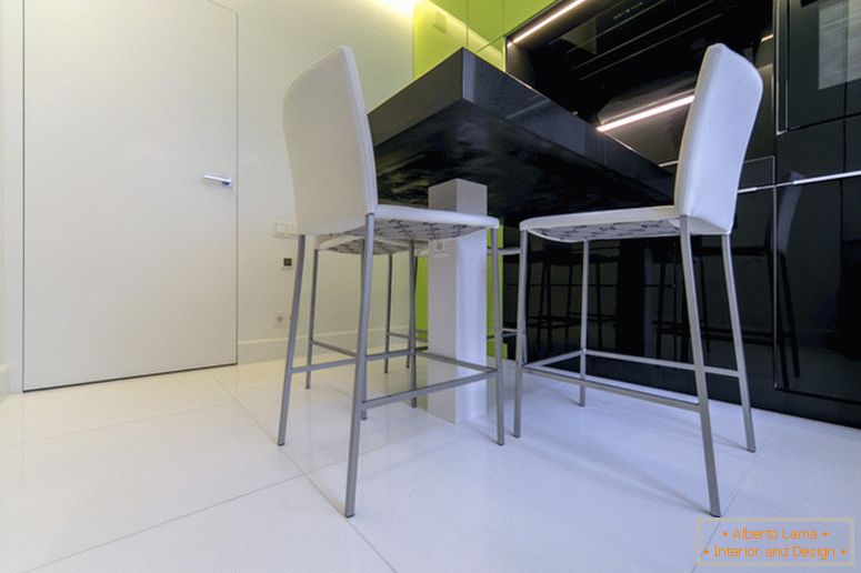 Бели столици на позадината на црна и зелена кујна