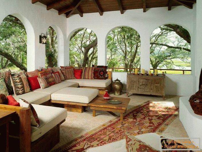 Верандата на селската куќа е украсена во согласност со медитеранскиот стил. Интересна карактеристика е декор со многу шарени перничиња.