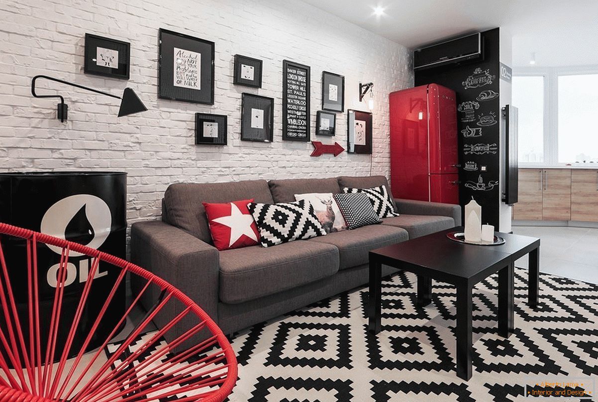 Црвени декор елементи во црно и бело студио стан
