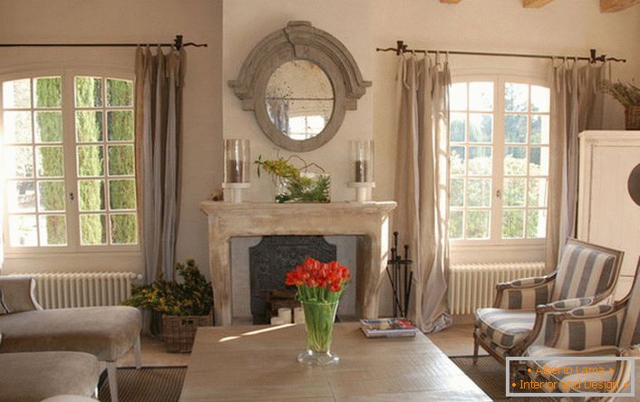 Дневна соба во стилот на земјата со белешки на романтизмот. Прекрасни големи прозорци и удобно мебел за дома. Одлична идеја за големо семејство.