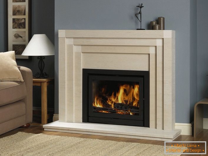 Во дневната соба огништето со пламена имитација врши не само декоративна функција. Во студената сезона, ја загрева просторијата.