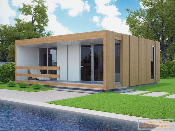 Една мала модуларна куќа со базен во дворот. Стилскиот дизајн на куќата што се гради брзо изгледа органски против позадината на кратка исечена косилка.