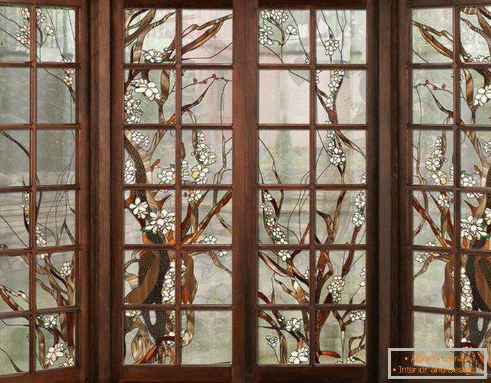 Прозорците во темната дрвена рамка се декорирани со витраж. Некомплицирана бројка погодна за внатрешен дизајн во стил на земја или модерна.
