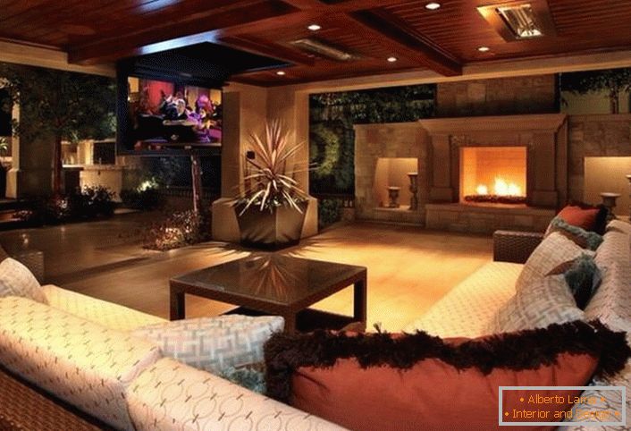 Стилски гостинска соба во модерен рустикален стил е украсен со голем камин. Дрвени тавани се органски вклопуваат во целокупниот ентериер.