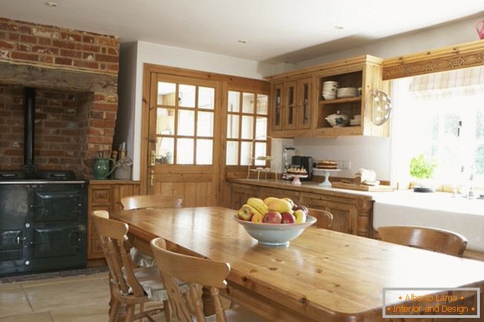 Пространа кујна во стилски стил. Дрвениот мебел и декорацијата од тули преку шпоретот му даваат стил на природен и романтичен стил.
