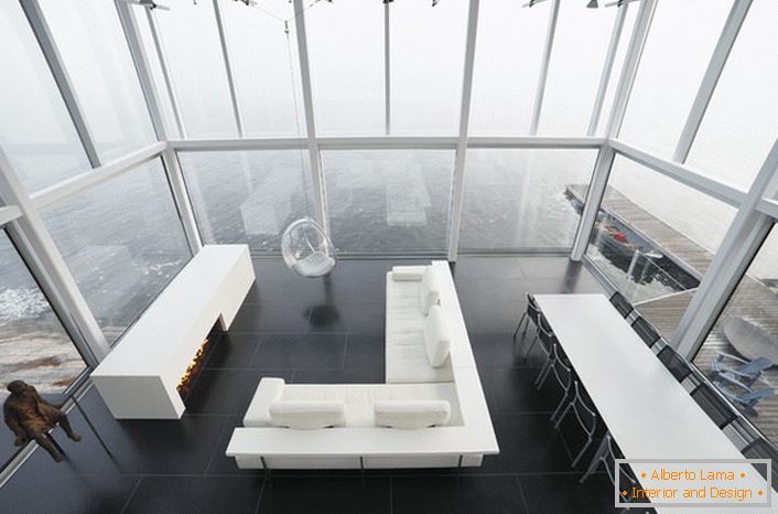 Лаконскиот дизајн на дневната соба во минималистички стил. Интересен дел од мебелот е столица суспендирана од висок плафон.