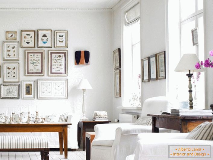 Пријатна дневна соба во скандинавски стил е направена во бела боја. Интересно е да се декорира ѕидот со рамки со различни големини.