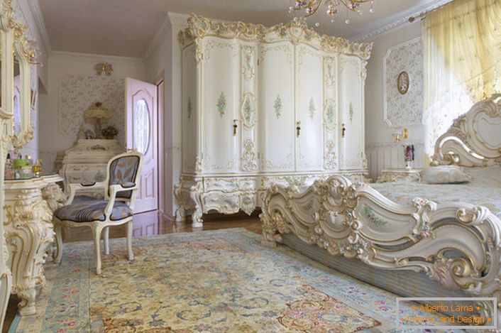 Снежана спална соба со врежан масивен мебел изработен од дрво. Креветот со висока глава на главата, елегантно се вклопува во внатрешноста во барокниот стил.