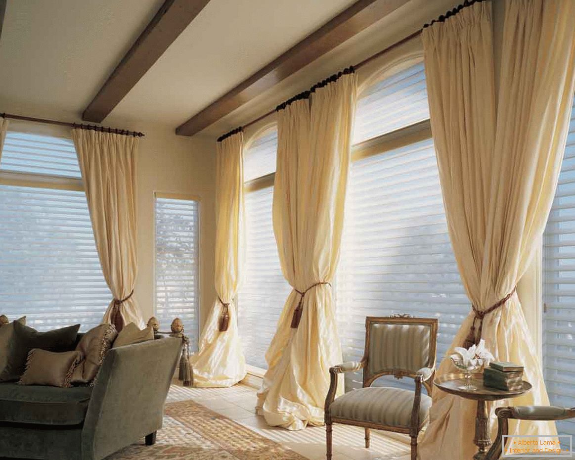 прекрасна дневна соба-завеси-сетови-со капка-тавани-дизајн-и-Браун-чиста-завеси-исто така-софа кревет-на-тепих и две фотелји-со-дрвени-мали маса