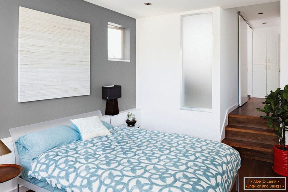 Сини постелнини и сиви ѕидови во спалната соба
