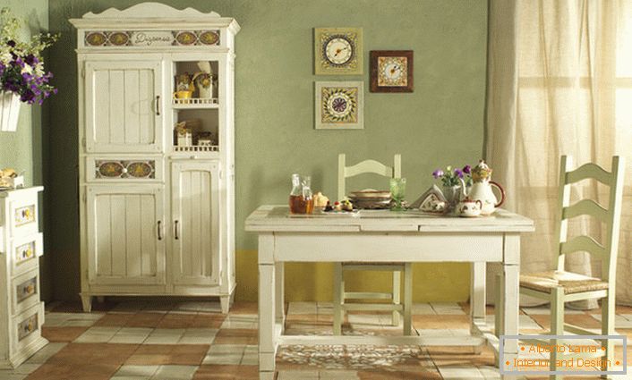 Уютна кујна во стилски стил се изведува во бела и нежна маслина. Совршена комбинација на бои за рустикален стил.