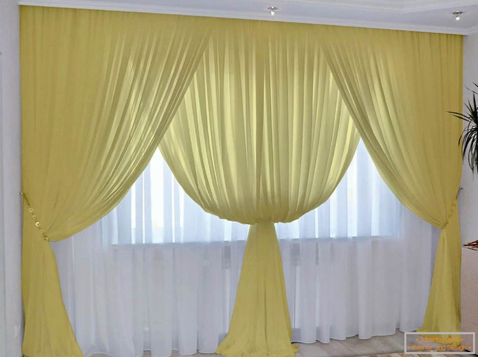 Жолта завеса и бел тул во собата