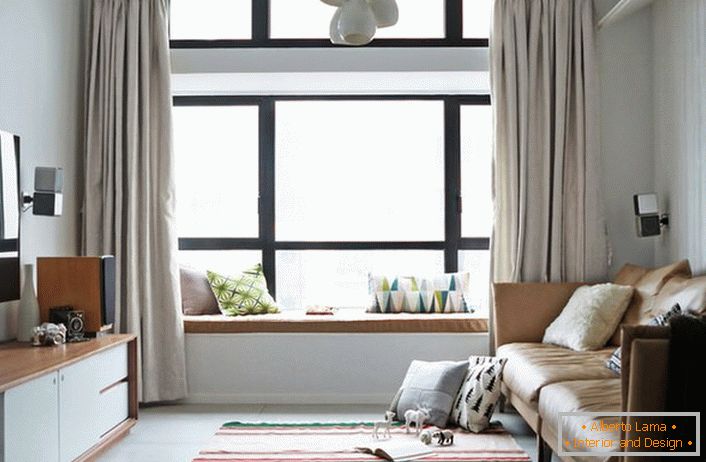 Едноставните еднобојни завеси на мирни бои се идеални за пространиот комплексен прозорец поделен на делови. А соба во скандинавски стил за еден млад човек чиј свет на музика и компјутер. 
