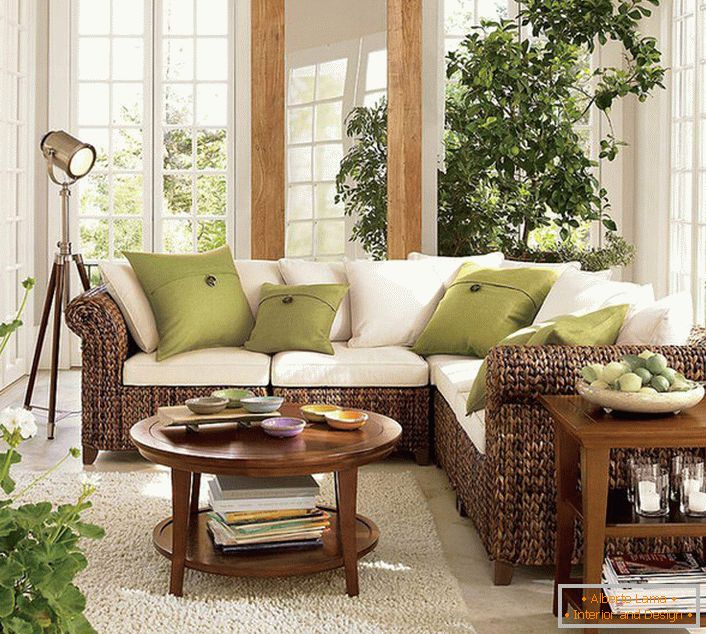 Големи прозорци со дрвени рамки во дневната соба во еко-стил овозможуваат доволна количина на сончева светлина, која треба да преовладува во собата.