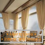 Завеси и ролетни на прозорците во дневната соба