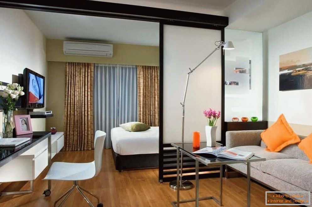 Спална соба и дневна соба во една просторија одделени со полутранспарентна преграда
