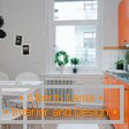 Бела кујна со портокал мебел