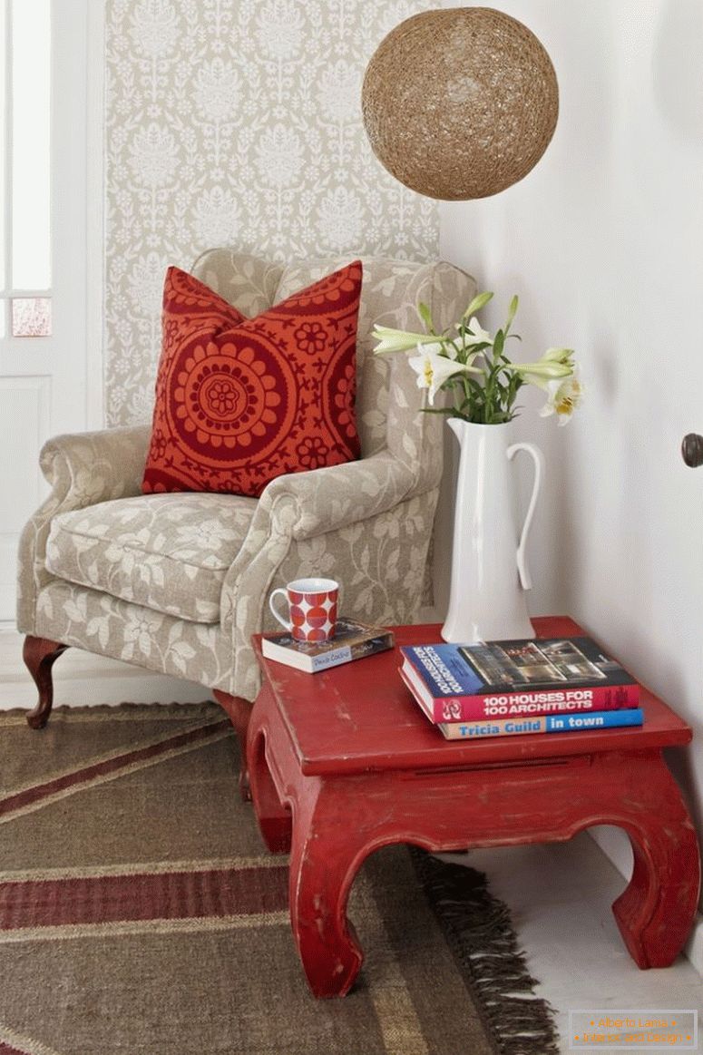 Читање агол; опиумска маса и бледа фотелја со украсени перничиња за расфрлање на ѕидот