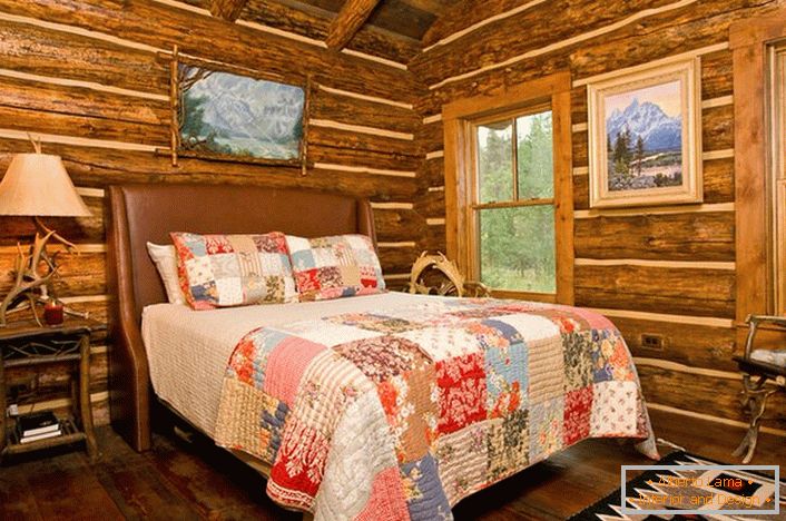 Спална соба во рустикален стил во лов дом. Интересно декорација на ѕидовите со помош на најавите куќа. 