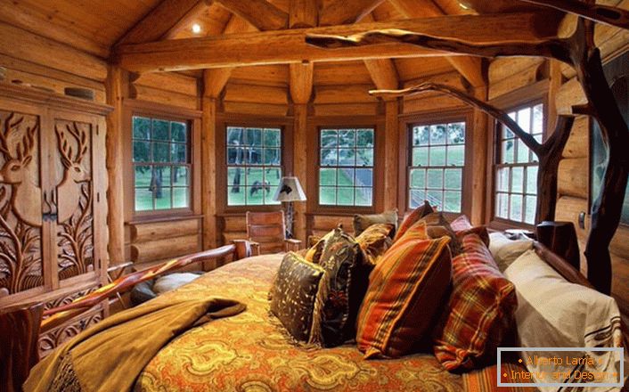 Една од спалните соби во куќата во близина на езерото е направена во стилот на руралната земја. Дрвена декорација. Масивни мебел и декор елементи се избрани во најдобрите традиции на стил.