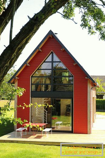 Внатрешност на мала дрвена куќа со големи прозорци