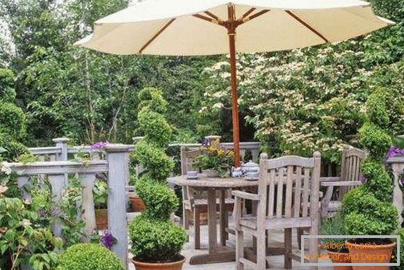 Дрвени мебел и ограда во пејзажот дизајн на дворот со свои раце
