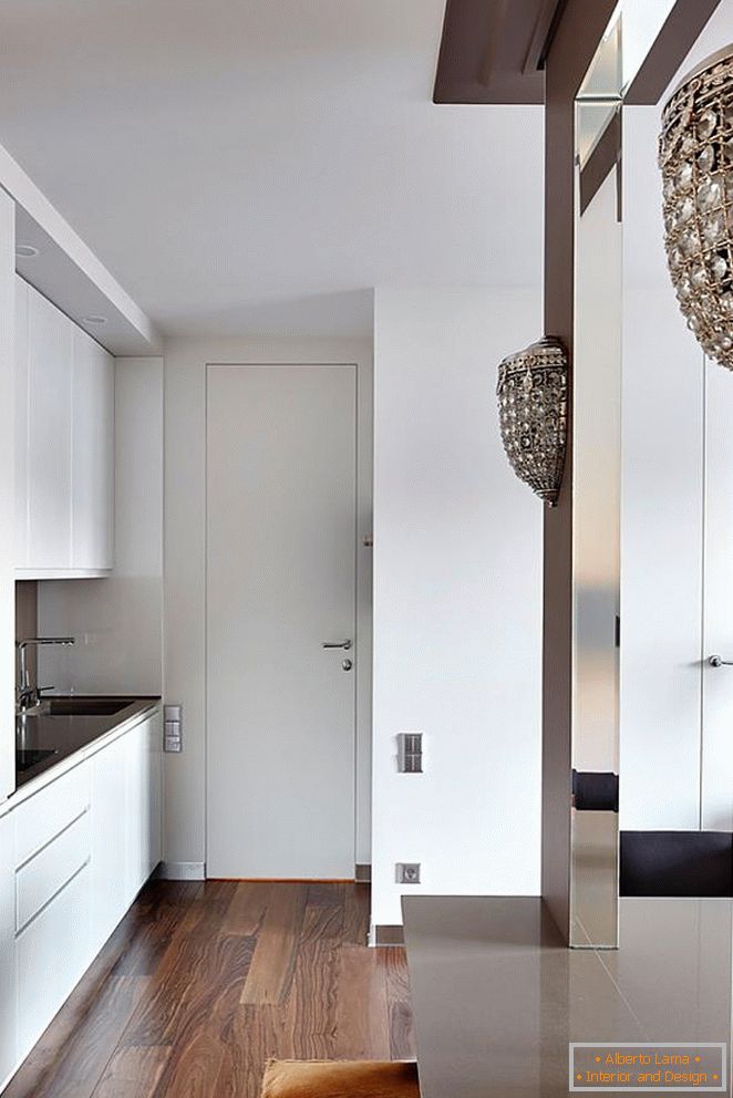 Бела кујна мебел, бела влезната врата и прекрасен дрвен паркет