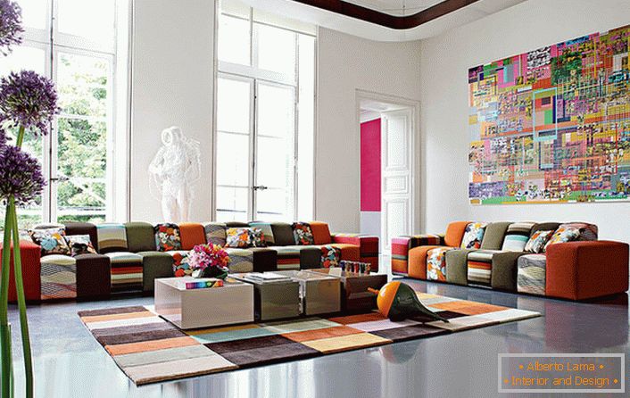 Шарена соба за гости во авангарден стил во голема куќа на италијанско семејство. Дизајнерската идеја компетентно ги комбинира тепихната покривка и мебелот со приближно идентична боја.