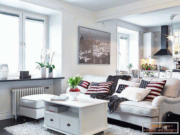 Уютниот студиски стан во скандинавски стил е украсен главно во бело. Прозорците без завеси овозможуваат доволно дневна светлина за да влезат во собата.