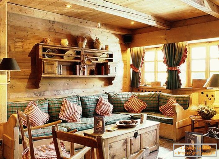 Дрвена ѕидна декорација, контрастни перници на мека троседот, густи завеси со возбудувања на прозорците. Уютна дневна соба во рустикален стил во селска куќа.