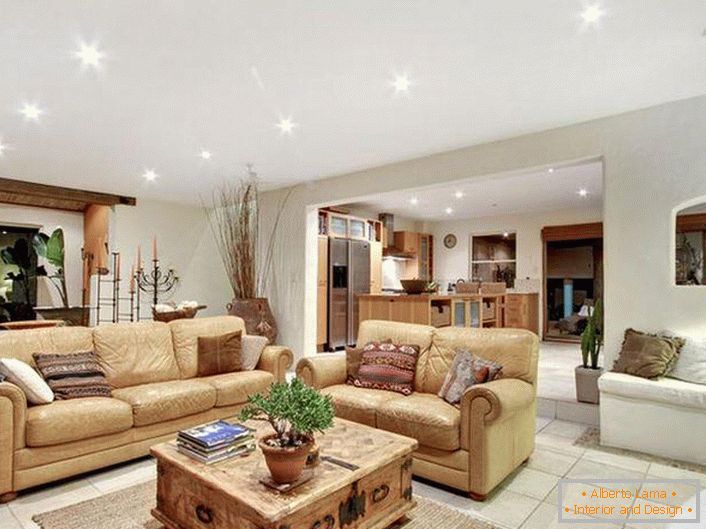 Луксузен, стилски ентериер во дневната соба во медитеранскиот стил. Мека, светло беж мебел, правилно избрано осветлување, плочки под - сведочам за медитеранскиот стил.