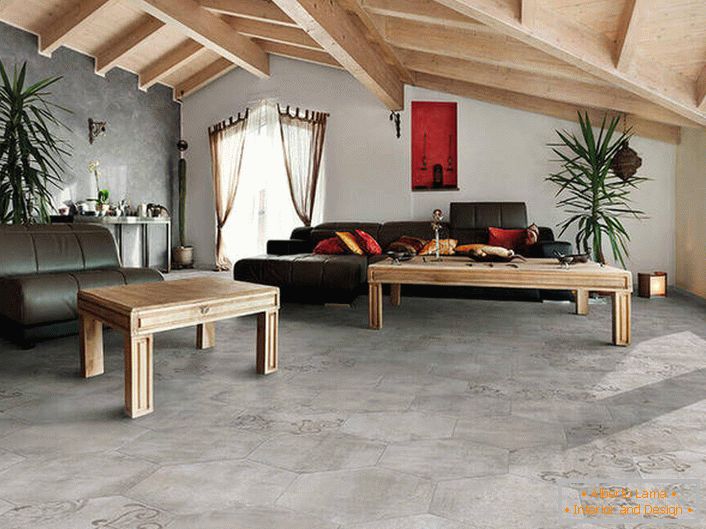 Покривот на подови и ѕидови имитира груб финиш. Таваните од дрво се комбинираат во заеднички состав со мебел. Среќна варијација на стилот на мансарда во дневната соба.