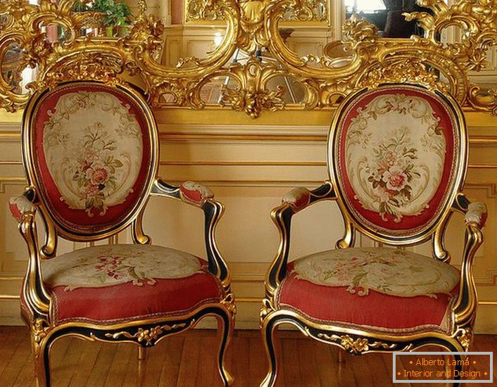 Материјал од златна боја на огледало и столици со црвено меко тапацир - светли претставници на барокниот стил.